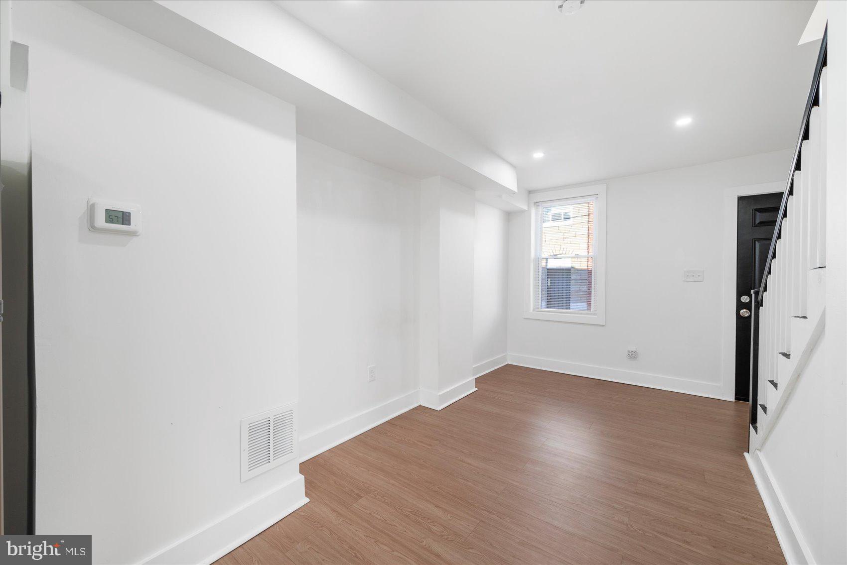 847 Reinhardt Street Baltimore, MD 21230 - Photo 6 of 41 an empty room with wooden floor and windows