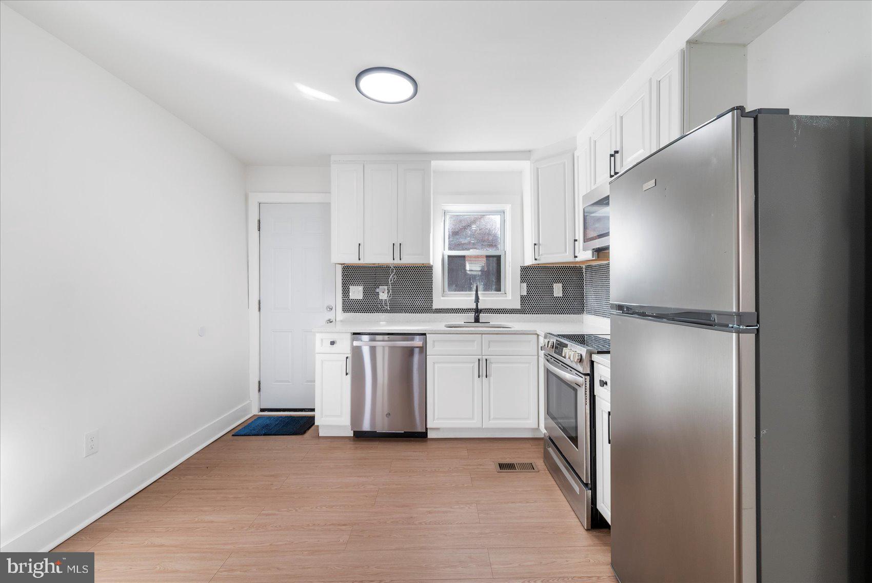 847 Reinhardt Street Baltimore, MD 21230 - Photo 10 of 41 a kitchen with stainless steel appliances a refrigerator sink and stove