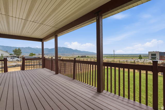 2567 West Rim Rock Drive Stockton, UT 84071 - Photo 45 of 64 Covered porch featuring wood-finish decking, brown railing, and a slatted ceiling