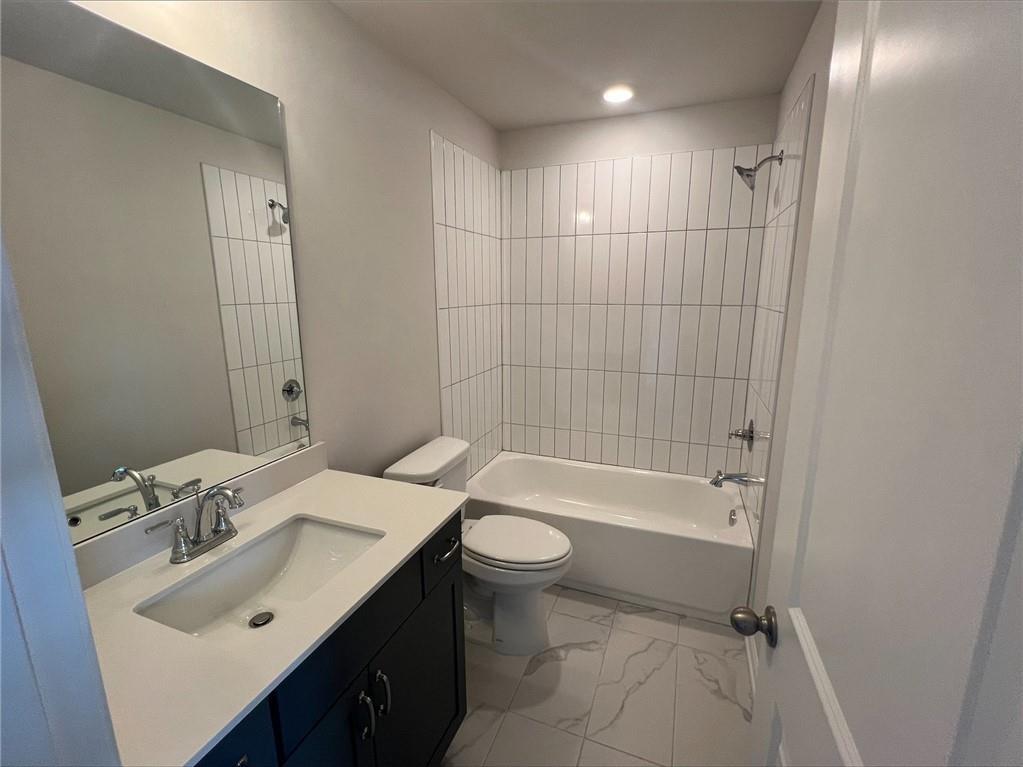 219 Willow Street Canton, GA 30114 - Photo 13 of 24 a bathroom with a bathtub shower sink mirror vanity and toilet