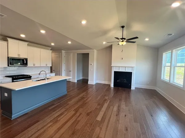 a large kitchen with cabinets wooden floor and stainless steel appliances