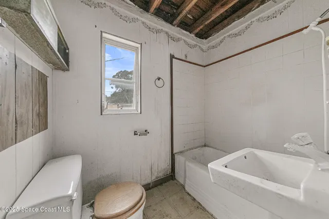 a white toilet sitting next to a bathroom sink and tub