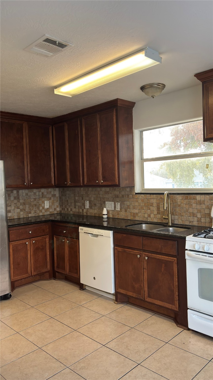 4911 Oleander Street, Unit B Pasadena, TX 77586 - Photo 16 of 34 a kitchen with granite countertop a sink cabinets and window