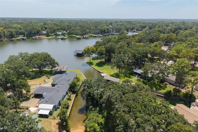 an aerial view of residential houses with outdoor space and lake view
