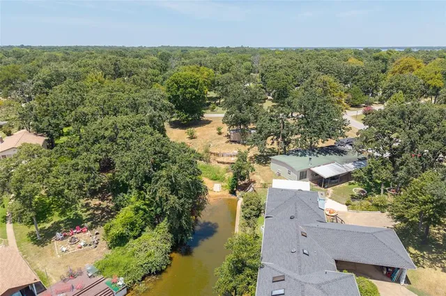 an aerial view of residential houses with outdoor space and trees