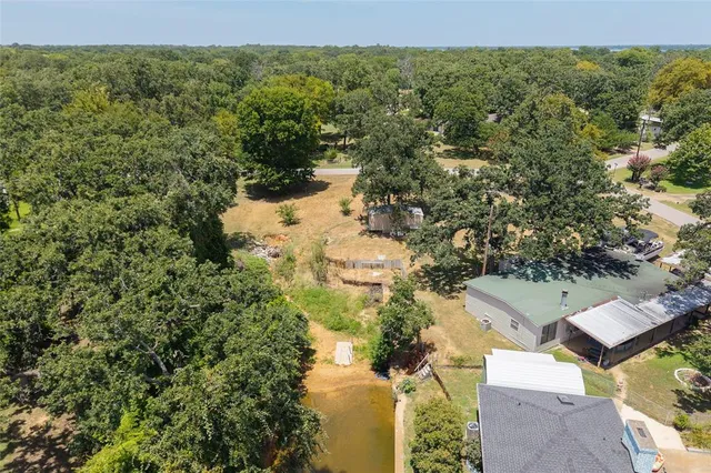 an aerial view of residential house with outdoor space and trees all around