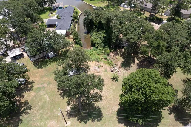 an aerial view of residential house with outdoor space and trees all around