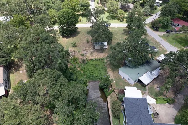 an aerial view of residential house with outdoor space and trees all around