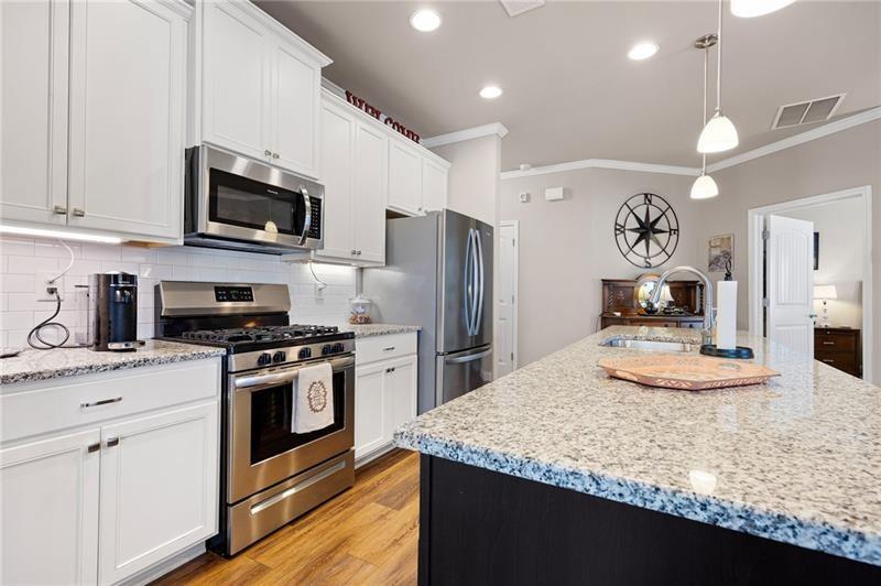 80 Azalea Crossing Dallas, GA 30132 - Photo 11 of 38 a kitchen with stainless steel appliances granite countertop a sink stove a refrigerator and microwave