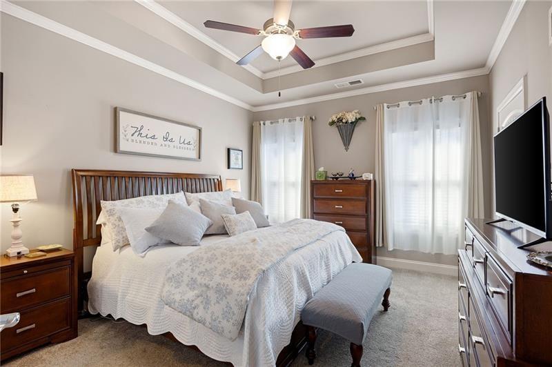 80 Azalea Crossing Dallas, GA 30132 - Photo 21 of 38 a bedroom with a bed flat screen tv and a chandelier