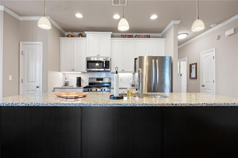 80 Azalea Crossing Dallas, GA 30132 - Photo 10 of 38 a kitchen with kitchen island granite countertop a refrigerator a sink a stove a microwave and wooden cabinets