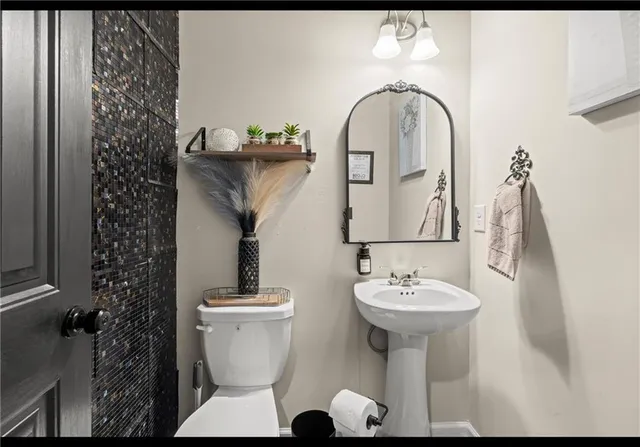 a bathroom with a sink toilet and a mirror