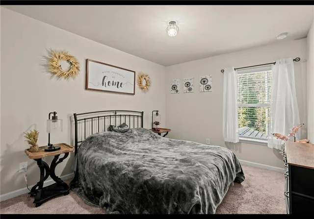 a bed sitting in a bedroom next to a window