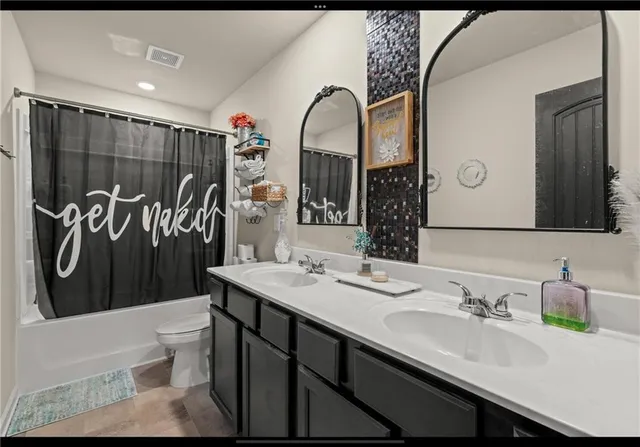 a bathroom with a sink a toilet and a mirror