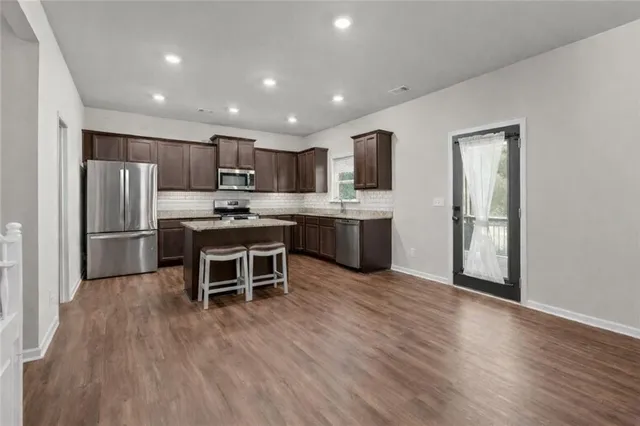 a kitchen with stainless steel appliances granite countertop a refrigerator stove and microwave