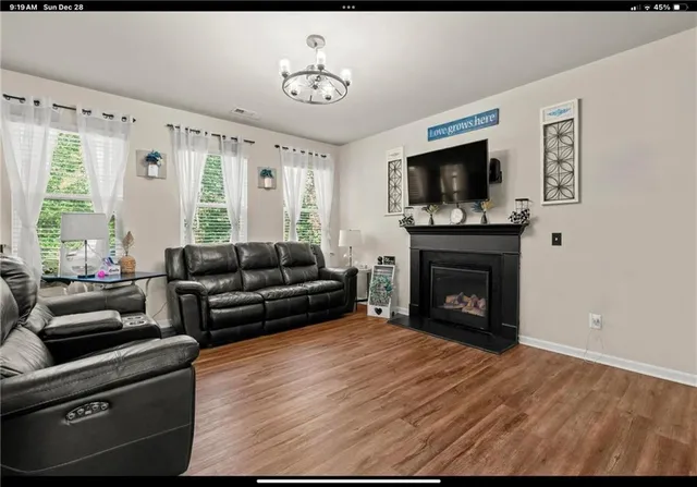 a living room with furniture a flat screen tv and a fireplace