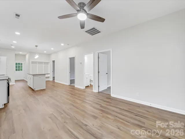 a view of a kitchen with wooden floor and a ceiling fan