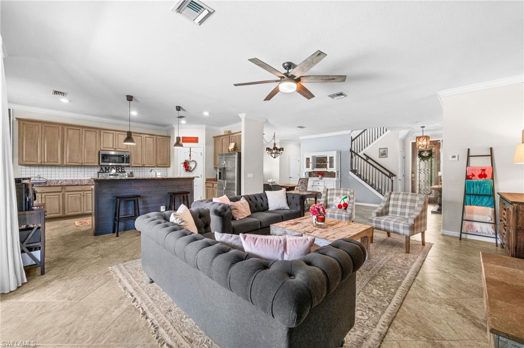 4754 Abaca Circle Naples, FL 34119 - Photo 8 of 46 a living room with furniture and a ceiling fan