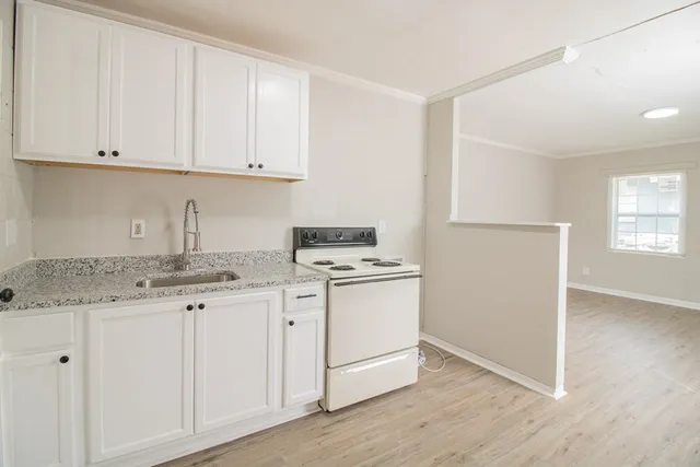 a kitchen with granite countertop white cabinets and white appliances