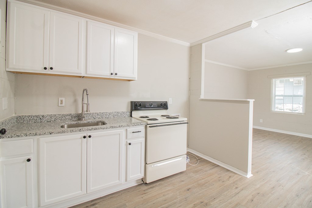 2408 16th Avenue, Unit B Columbus, GA 31901 - Photo 2 of 8 a kitchen with granite countertop white cabinets and white appliances