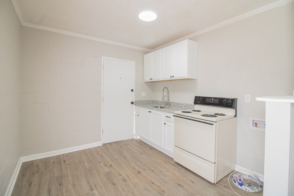 2408 16th Avenue, Unit B Columbus, GA 31901 - Photo 4 of 8 a kitchen with a stove cabinets and wooden floor