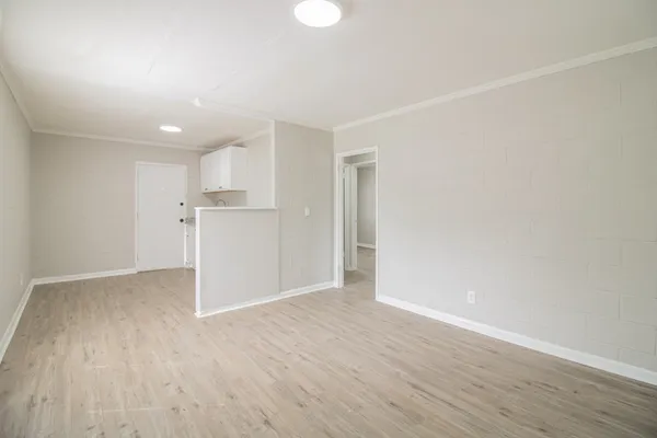 a view of empty room with wooden floor