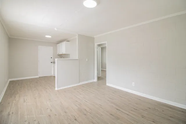 a view of empty room with wooden floor