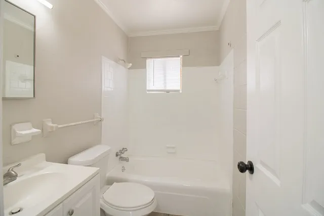 a white toilet sitting next to a bath tub