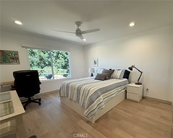 a spacious bedroom with a bed a couch and large mirror in it