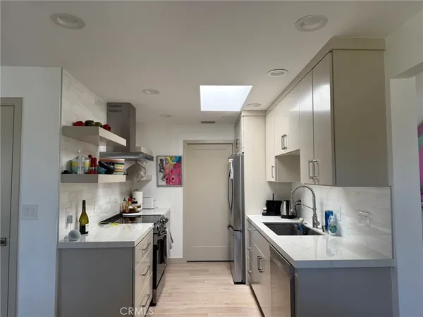 a kitchen with stainless steel appliances granite countertop a lot of cabinets