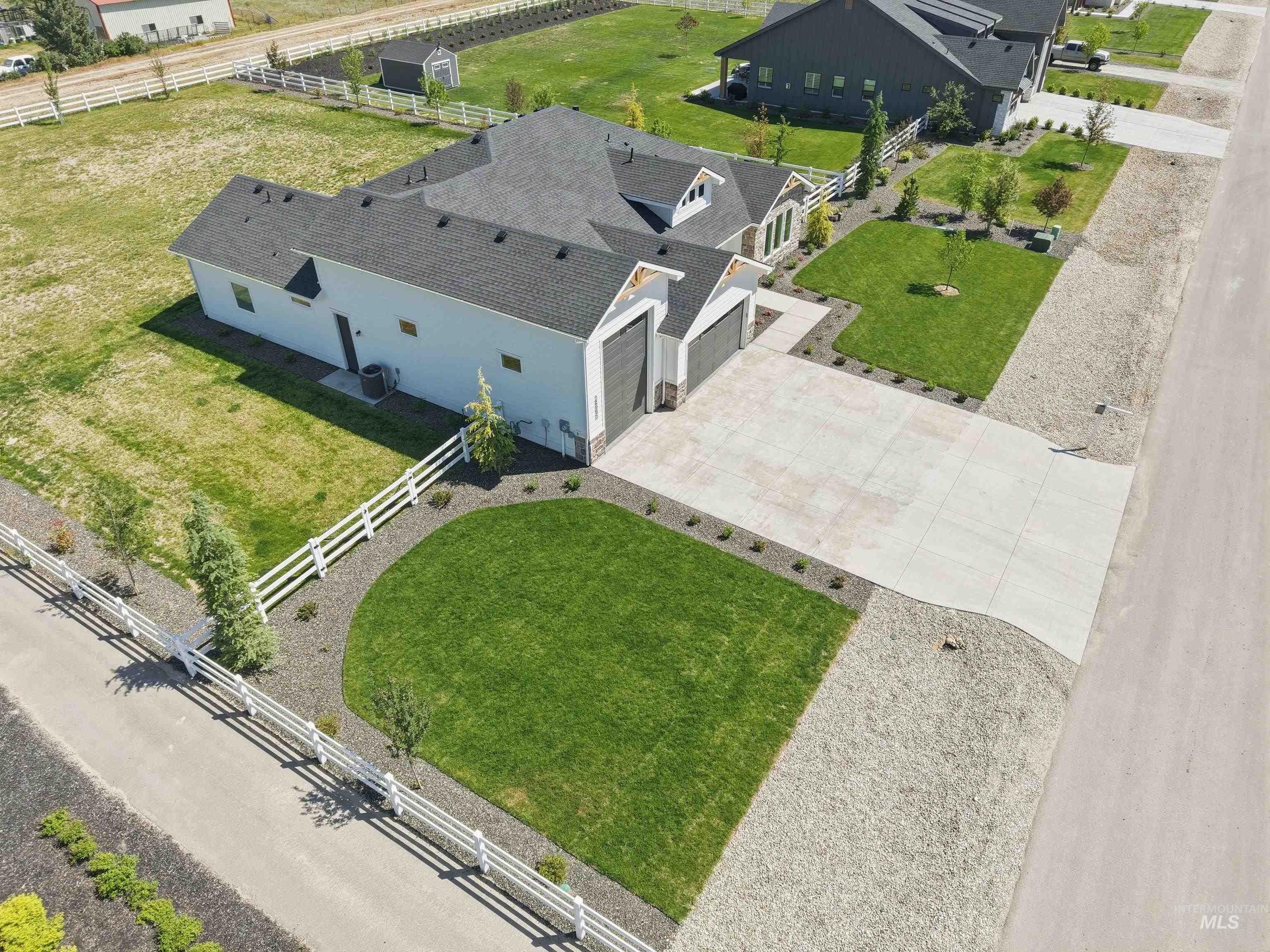 24990 Belgian Way Middleton, ID 83644 - Photo 46 of 50 Contemporary residence featuring a two-car garage with modern doors, a paved driveway, and manicured lawns