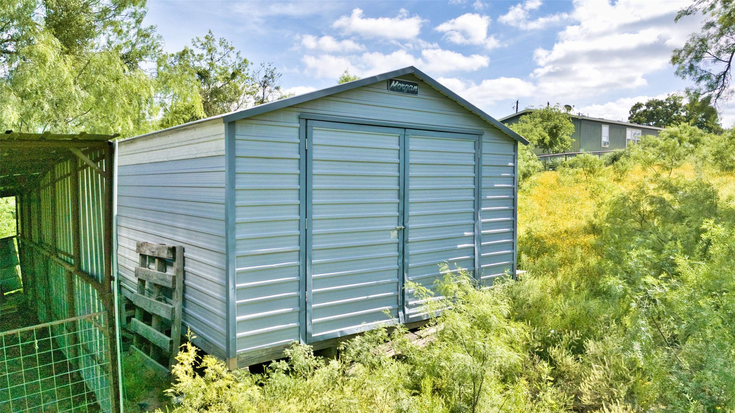 904 Bluebonnet Road Mason, TX 76856 - Photo 24 of 28 Metal storage shed with double entry doors and an adjacent fenced enclosure