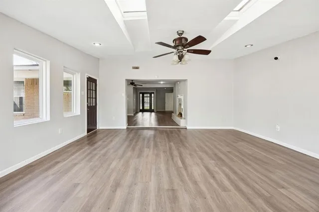 a view of empty room with wooden floor and ceiling fan