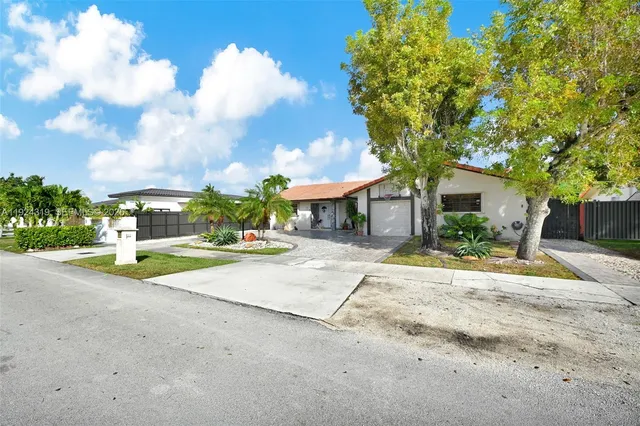 a view of a house with basket ball court and a small yard