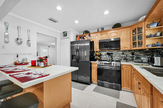 a kitchen with stainless steel appliances granite countertop a sink dishwasher stove top oven and refrigerator