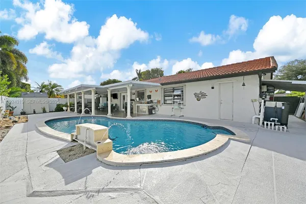 a view of a house with swimming pool and sitting area