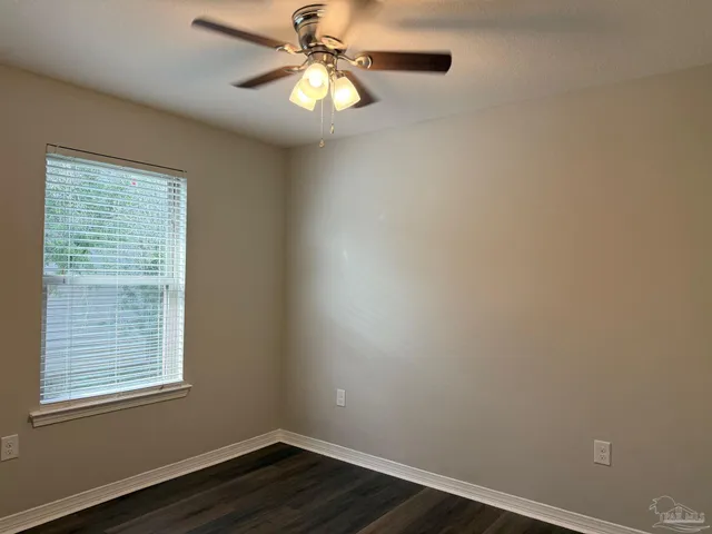 an empty room with a window and wooden floor