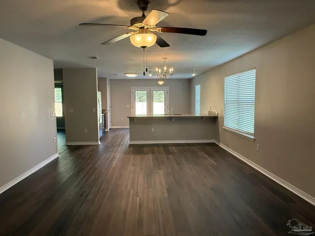 a view of wooden floor and a chandelier fan in a room