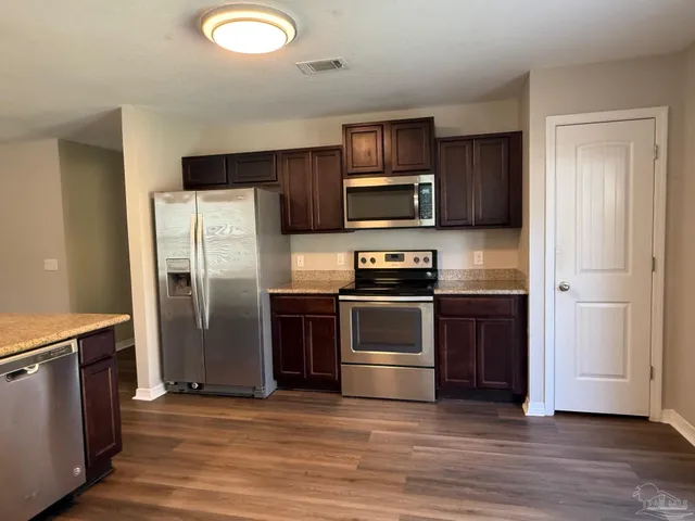 a kitchen with stainless steel appliances and wooden cabinets