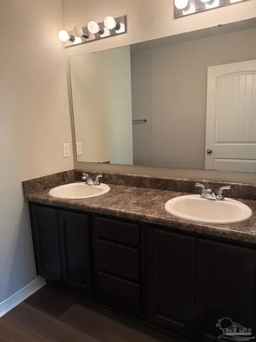 a bathroom with a double vanity sink and a mirror