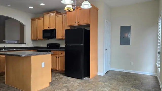 a kitchen with stainless steel appliances granite countertop a refrigerator a stove a microwave and island