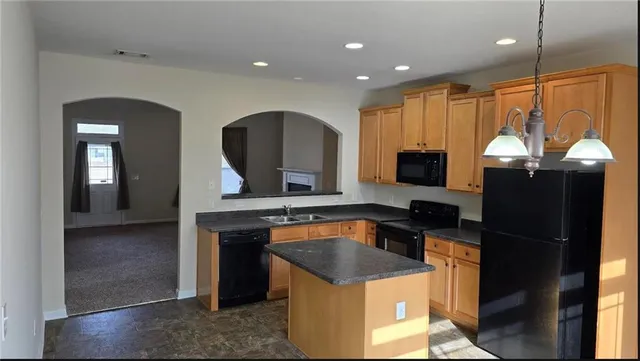 a kitchen with stainless steel appliances granite countertop a sink a stove and a refrigerator