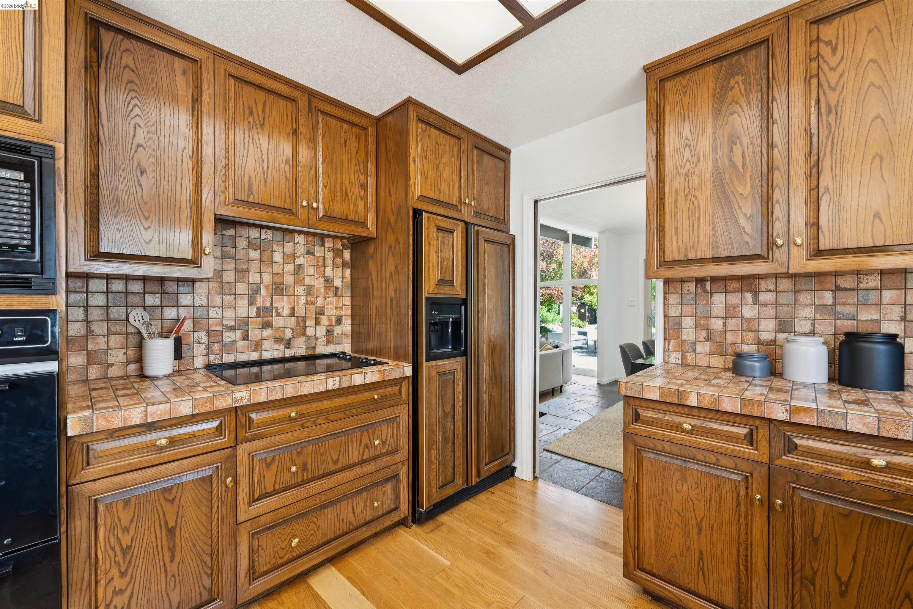 7 Jo Lin Court El Sobrante, CA 94803 - Photo 45 of 99 Kitchen featuring abundant wood cabinetry, tile countertops, and a tile backsplash