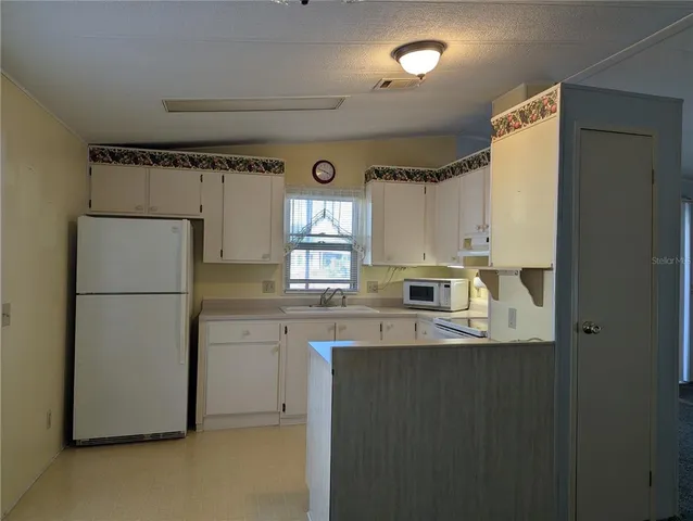 a kitchen with refrigerator and window
