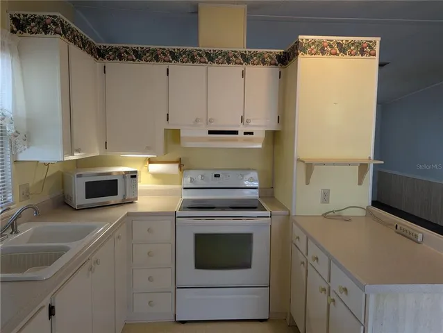 a kitchen with granite countertop a sink stainless steel appliances and cabinets