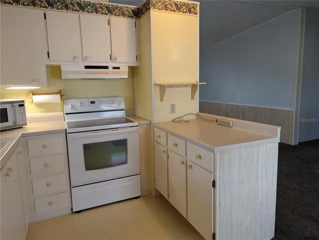 a kitchen with cabinets appliances and a window