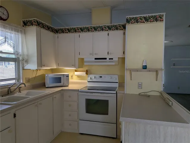 a kitchen with a stove and white cabinets