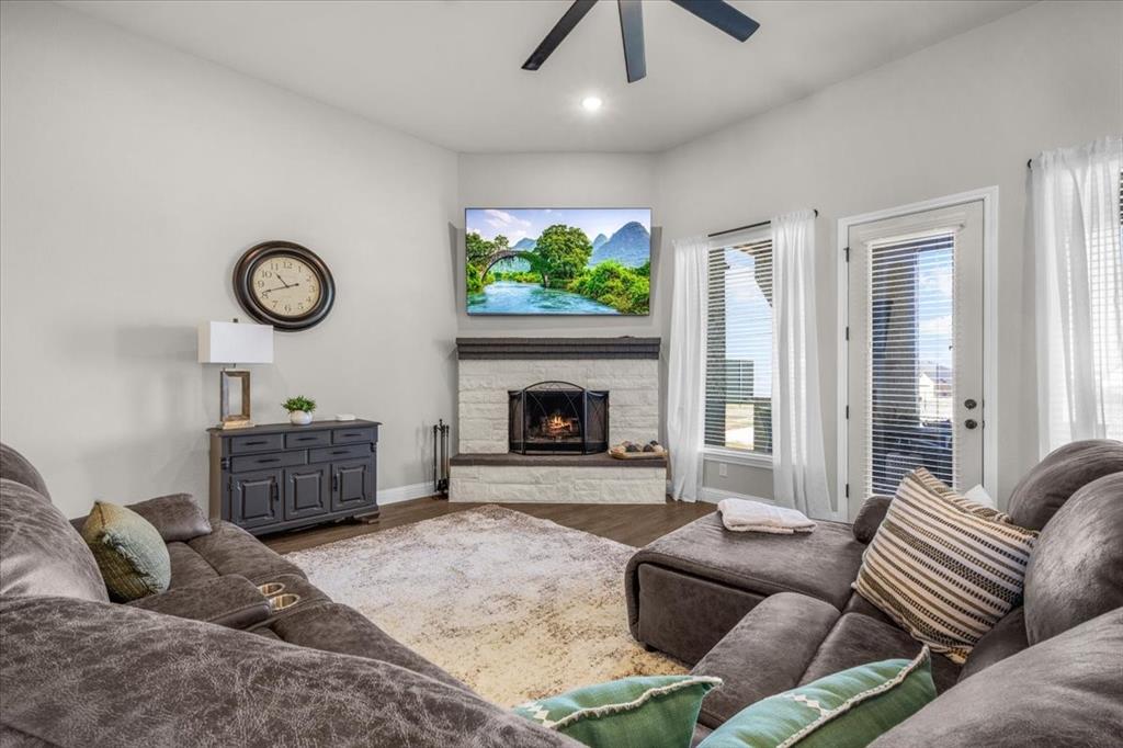 329 Palo Alto Drive Springtown, TX 76082 - Photo 8 of 34 Living area featuring a white stone fireplace with dark mantel and multiple window-door combinations providing natural lighting