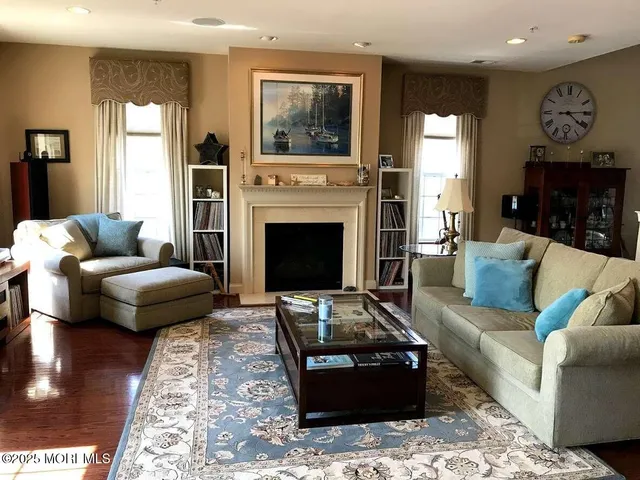 a living room with furniture a fireplace and a rug