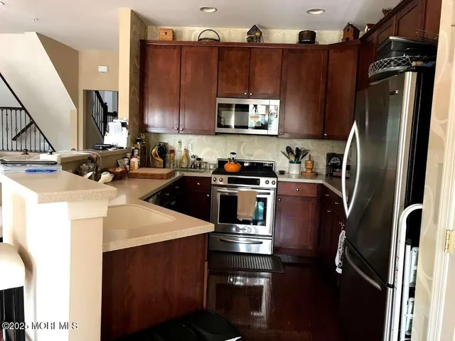 a kitchen with a sink a refrigerator and a stove top oven